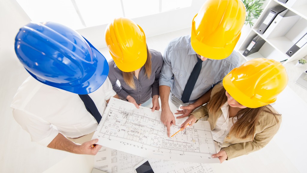 Top view of four successful architect checking the architectural plans.