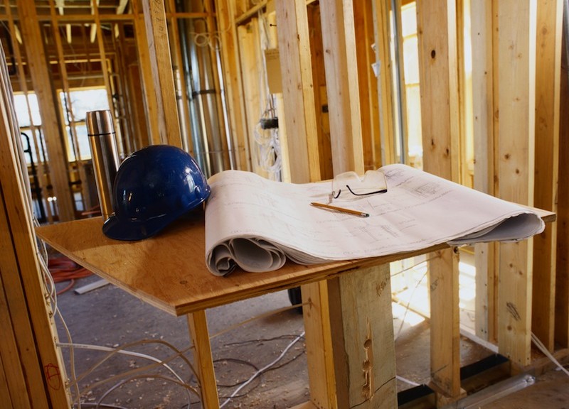 Blueprint and a Hard Hat Inside a Building Frame