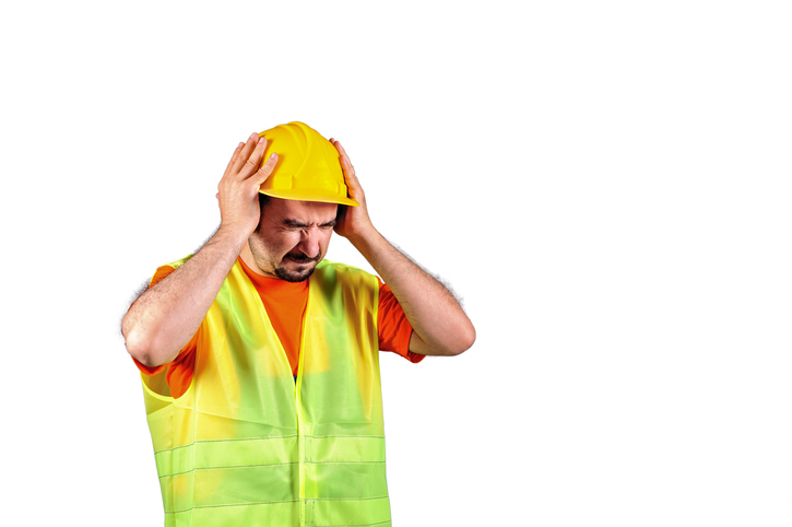 Manuel worker protecting himself from noisy environment isolated on white