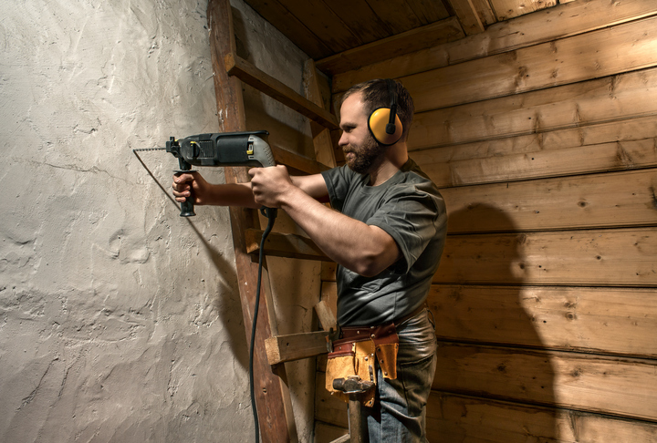 construction worker drill perforate concrete wall