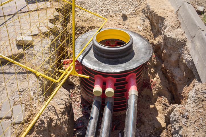 Excavation pit, electrical cables and optical fibres