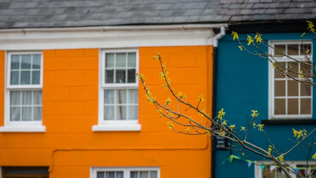 Orange and blue home facades in a small picturesque irish town Sneem on the Ring of Kerry route, Ireland